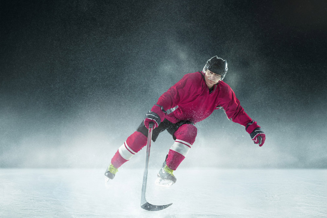 male-hockey-player-with-stick-ice-court-dark-wall-fabric-insulated