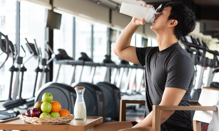 handsome-man-drinking-protein-shake-milk-many-kind-fruits-nourishing-body-daily